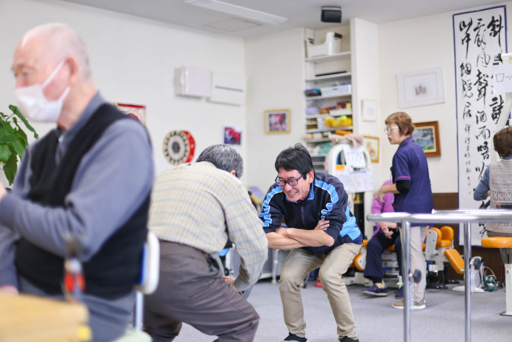 ご利用者さまのトレーニングを笑顔で補助するスタッフの様子