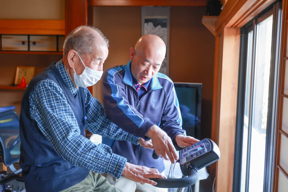 ご利用者さまのトレーニングを笑顔で補助するスタッフの様子